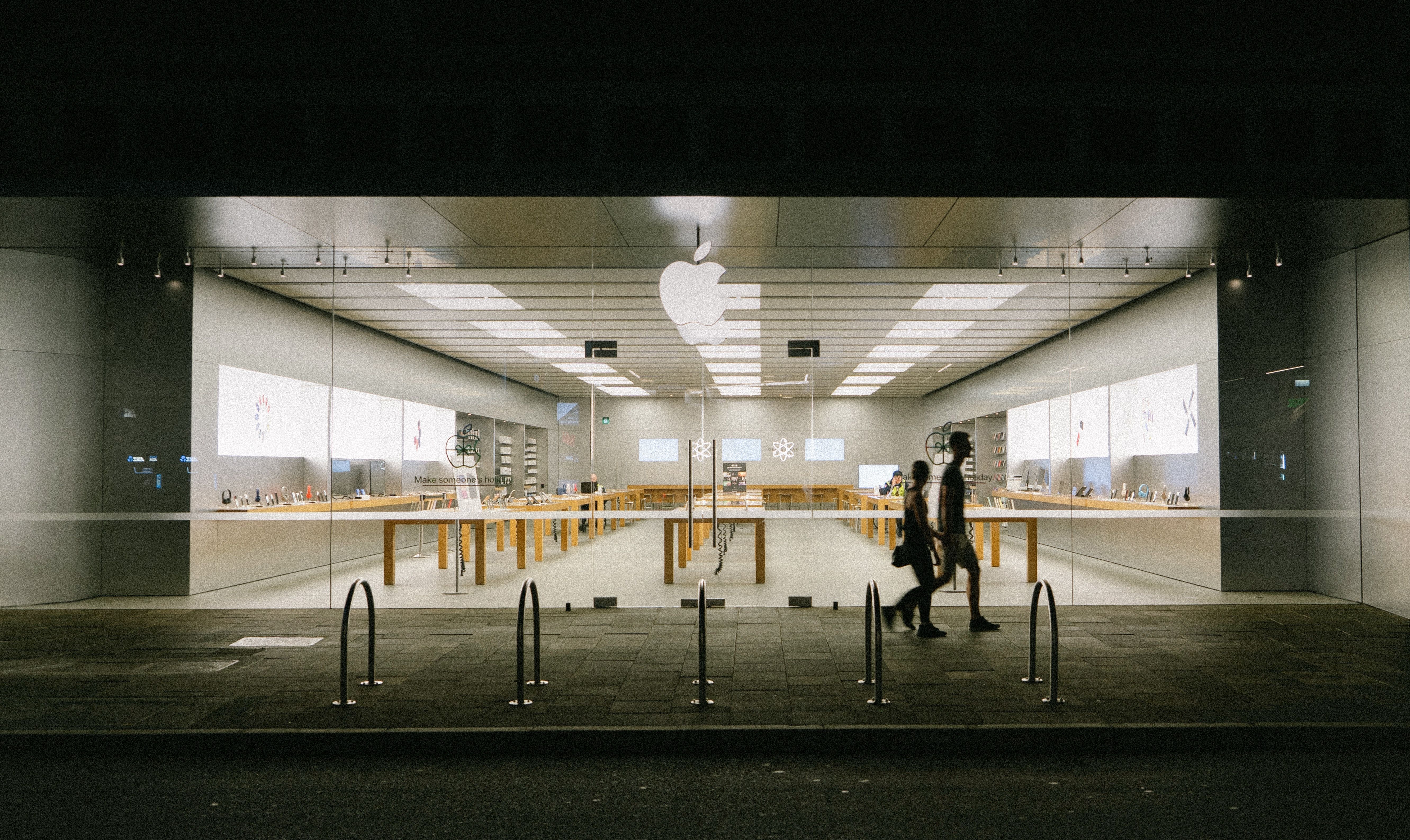 Des passants devant un Apple Store