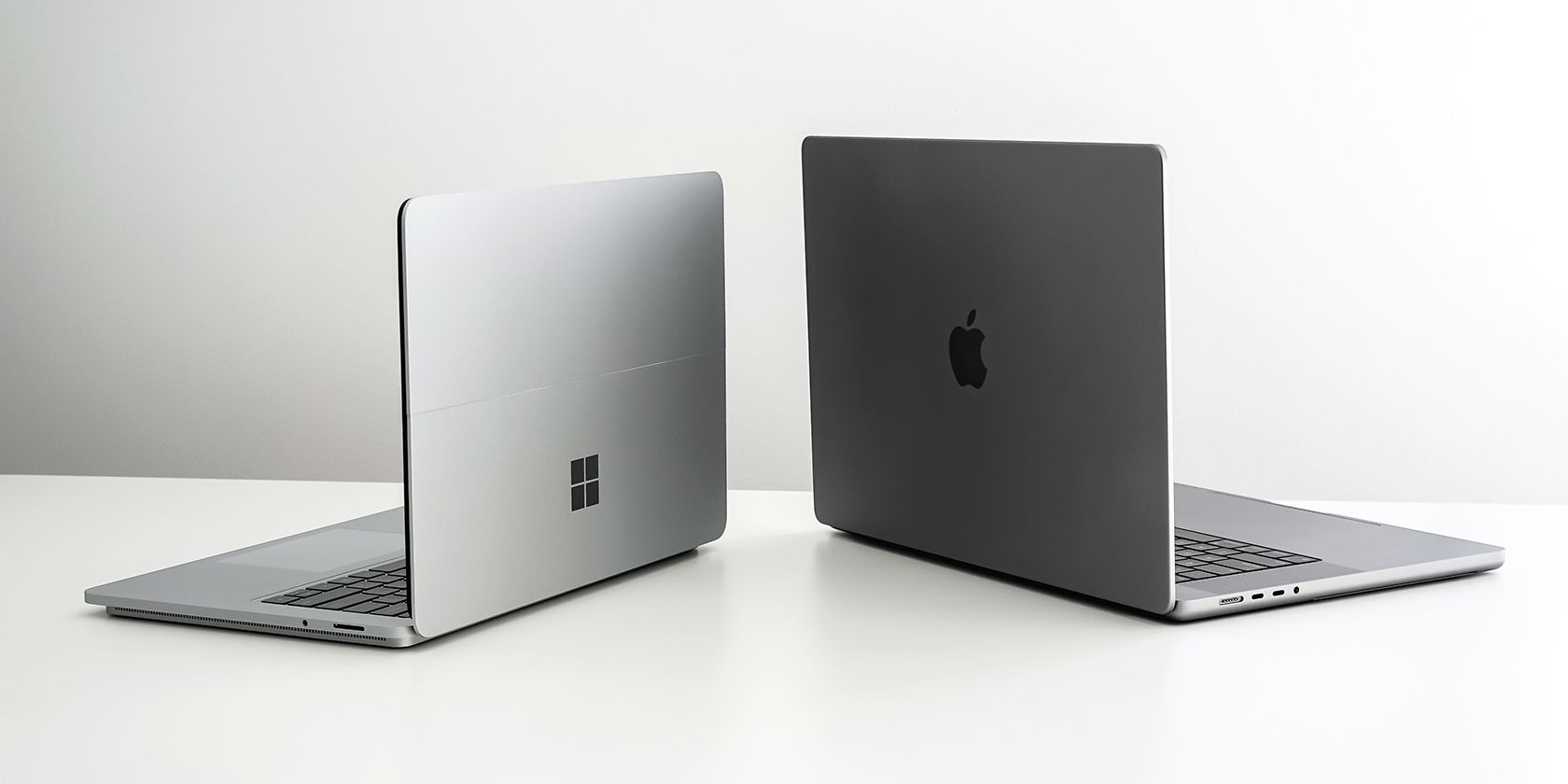 Un Mac et un ordinateur portable Windows placés côte à côte sur une surface blanche