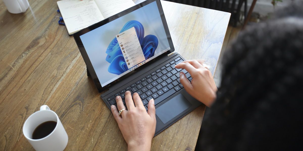 Une personne utilisant un ordinateur Windows sur un bureau marron