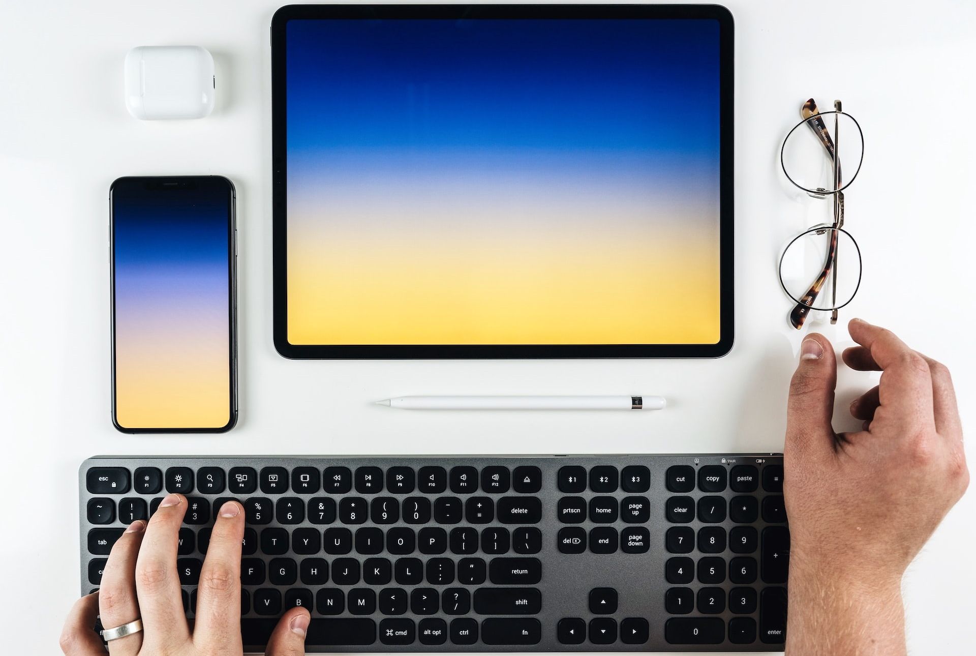 iPad Pro, iPhone, Magic Keyboard et AirPods sur un bureau